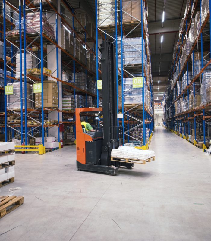 Industrial building large warehouse interior with forklift and palette with goods and shelves.